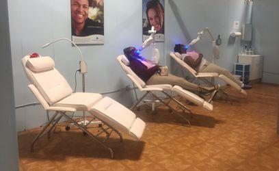 A teeth whitening group session that appears to be in a kiosk or mall set up, multiple chairs with multiple clients receiving teeth whitening at the same time